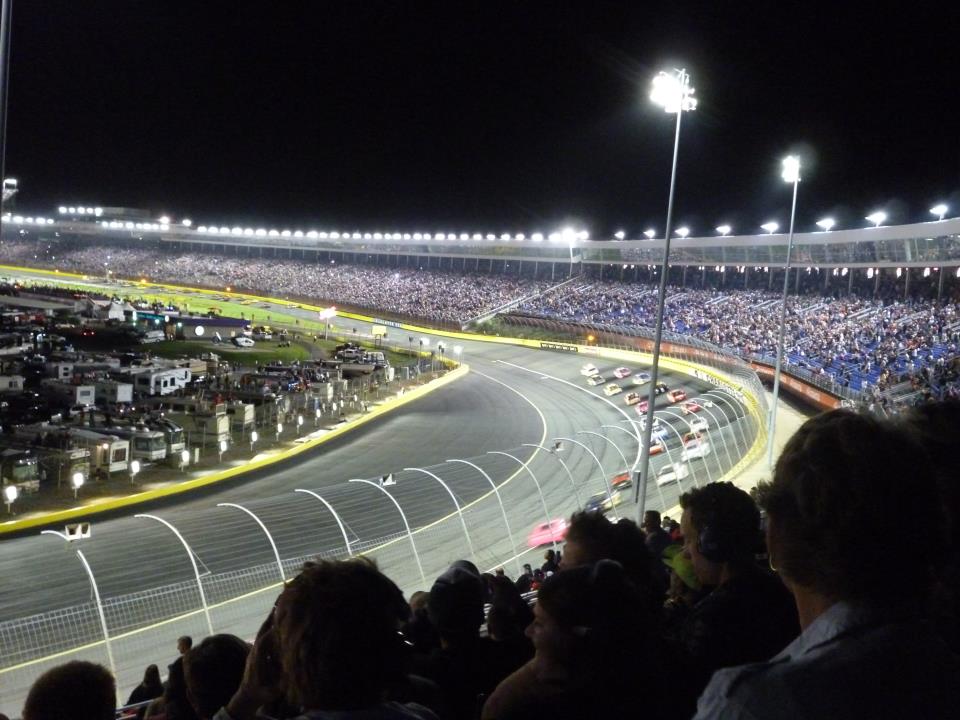 A picture of a NASCAR race at night.